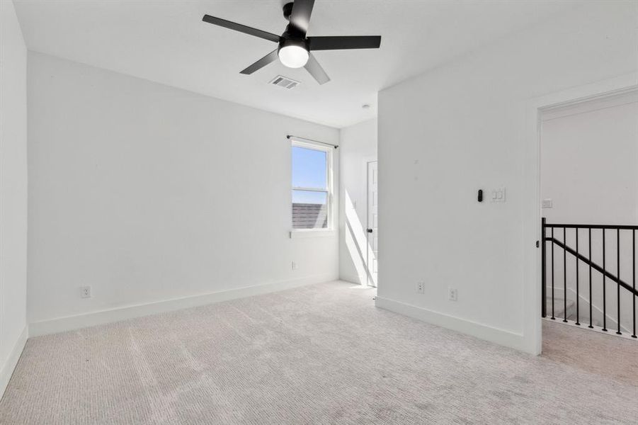 Carpeted spare room featuring ceiling fan