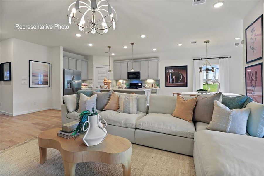 Living room featuring sink, a chandelier, and light hardwood / wood-style flooring