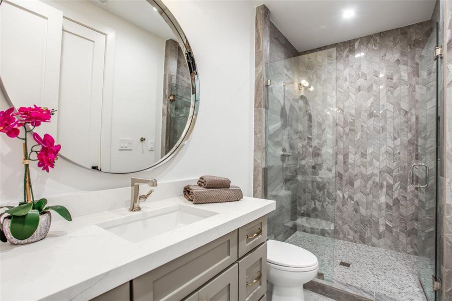 Bathroom with walk in shower, vanity, and toilet