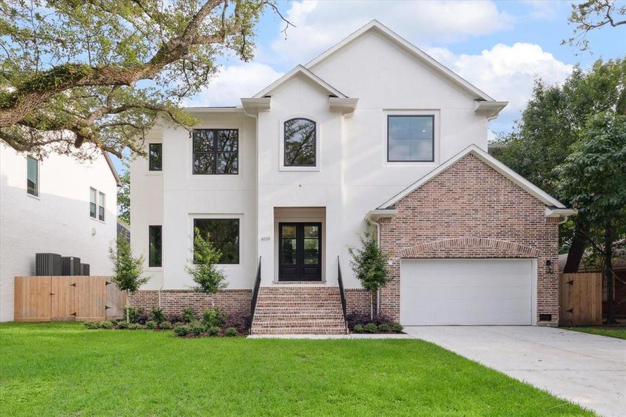 This is a transitional two-story home with a white exterior, brick accents, and a two-car garage on a quiet cul-de-sac lot. With minutes to the medical center, shopping and downtown, it features large windows, a well-manicured lawn with no back neighbors.