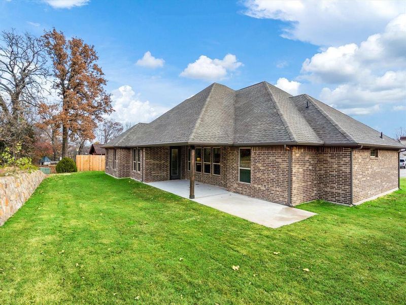 Rear view of house with a lawn and a patio area