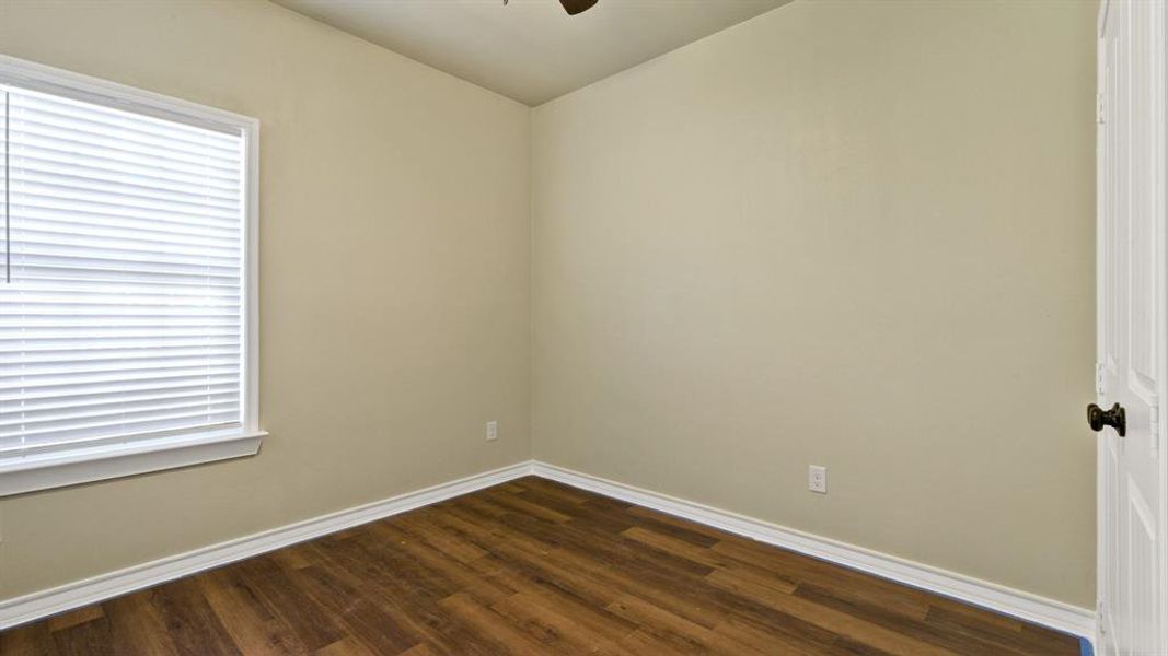 Unfurnished room with ceiling fan and dark hardwood / wood-style floors