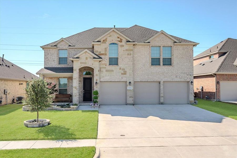 View of front of property featuring a front yard and a 3 car garage