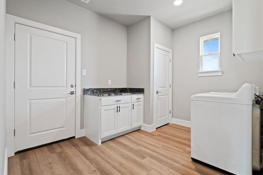 Laundry area with light hardwood / wood-style floors and washer / dryer