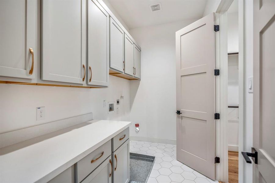 Large utility room with plenty of storage space and holds a full-sized washer and dryer.