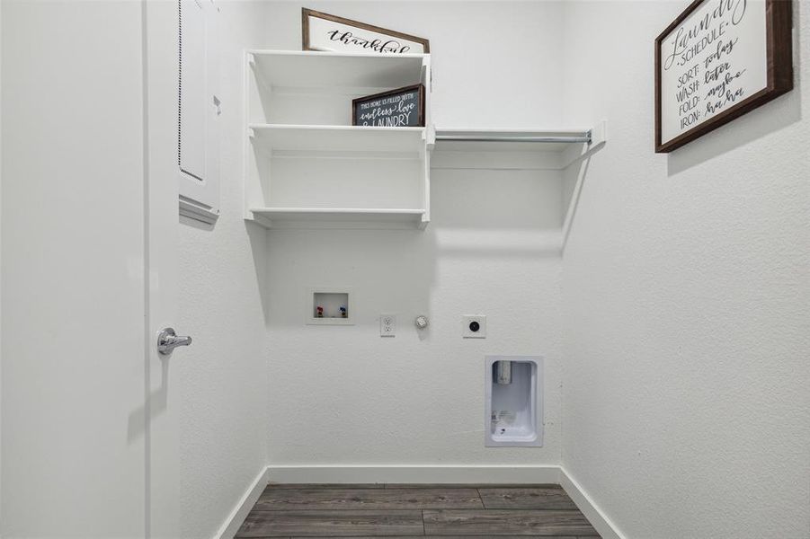 utility room with built in shelves and hanging rod.