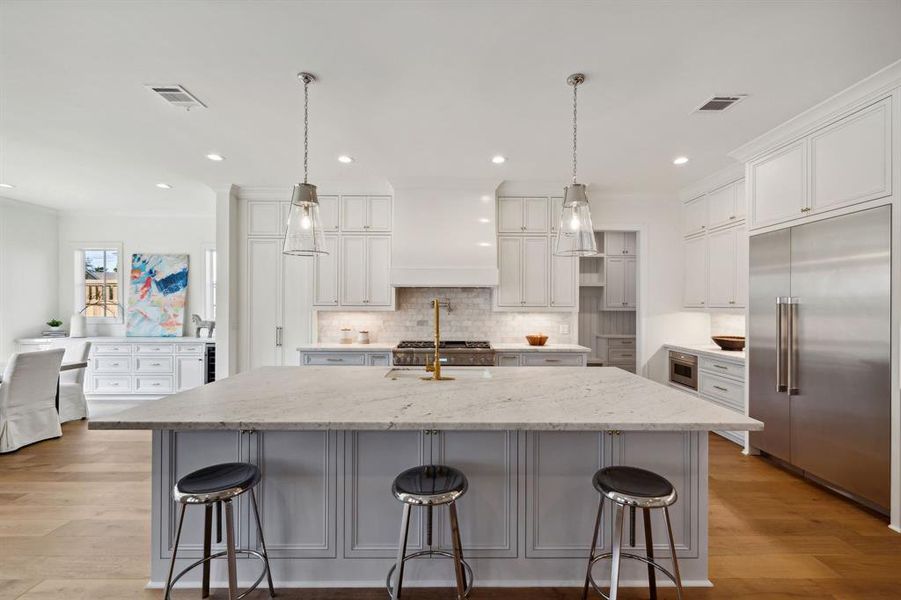 What kitchen dreams are made of! Island kitchen with marble countertops, Thermador appliances including built-in refrigerator and gas cooktop. A tremendous amount of storage, under cabinet lighting and pendant lighting.