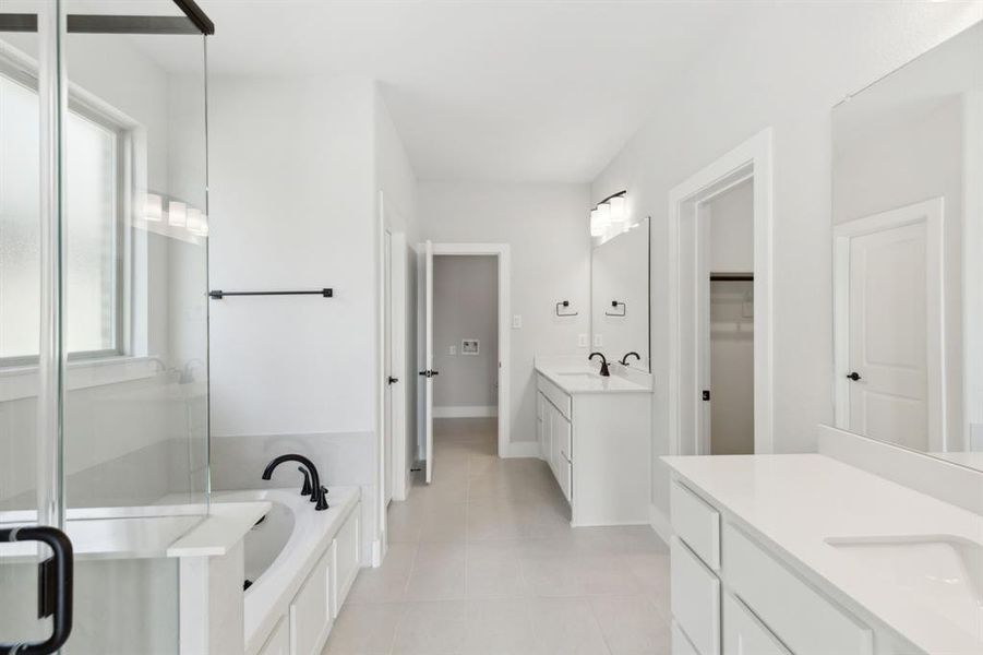 Bathroom with a bath, vanity, and tile patterned floors