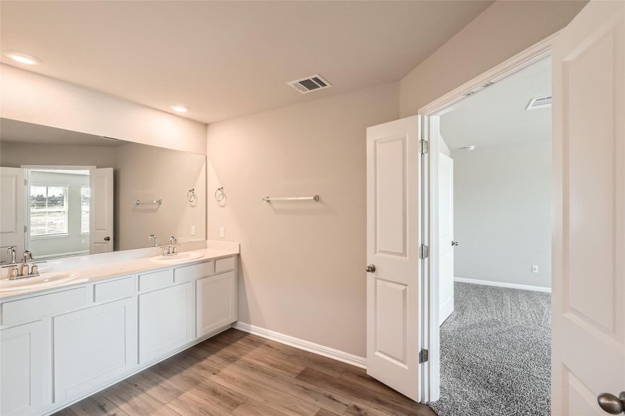 The ensuite bathroom provides a spacious dual vanity with timeless cabinetry.