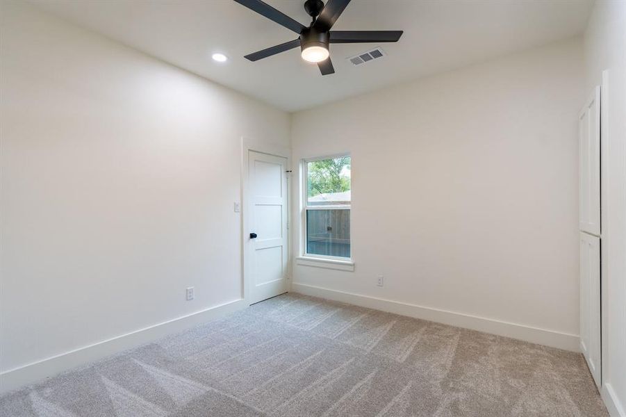 Empty room featuring light colored carpet and ceiling fan