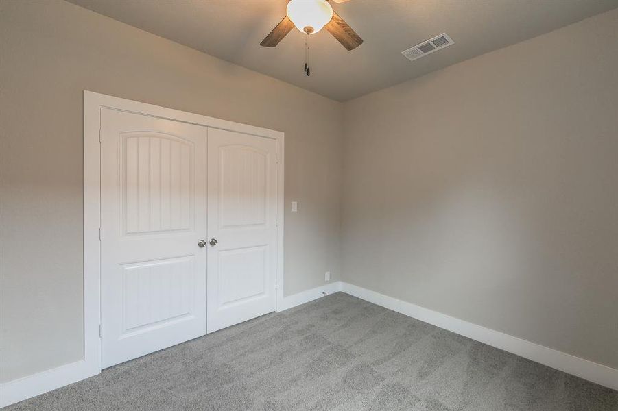 Unfurnished bedroom featuring carpet, a closet, and ceiling fan