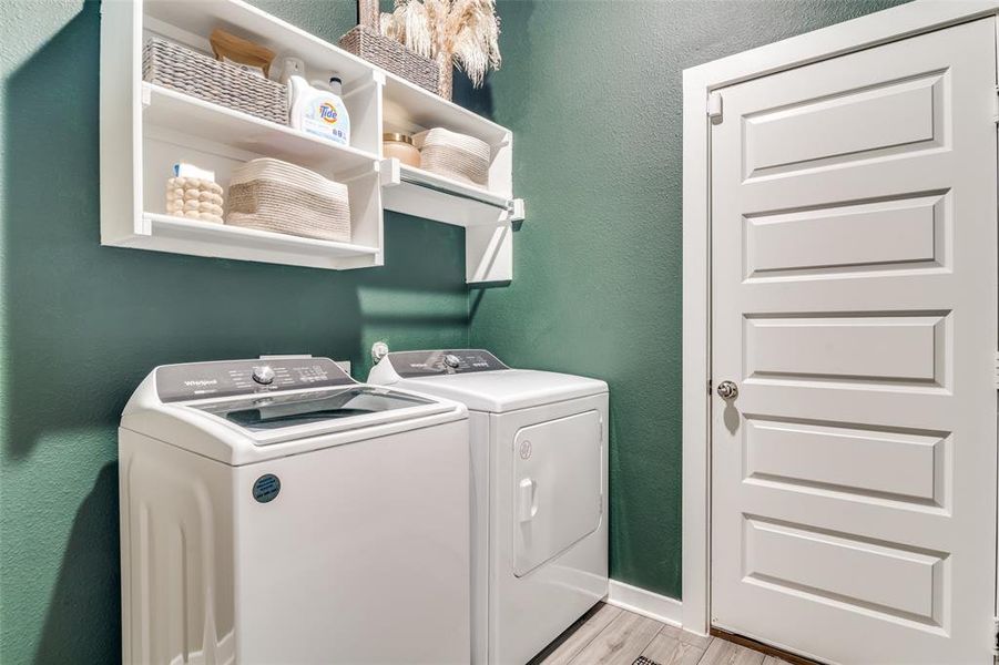 Laundry room featuring separate washer and dryer and light wood-type flooring