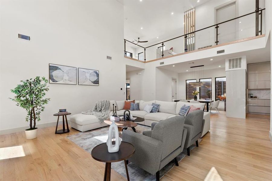 Living room with light wood-type flooring and a high ceiling