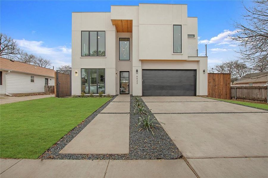 Contemporary house featuring a front yard and a garage