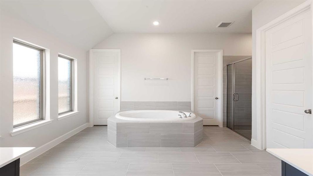 Bathroom featuring tile patterned floors, vanity, and a healthy amount of sunlight