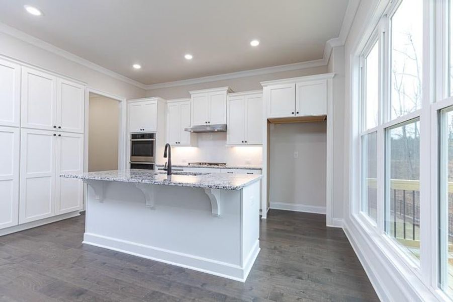 Kitchen with lots of cabinets, a center island and upgraded appliances.  Photo not actual home, but previously built Mansfield plan.