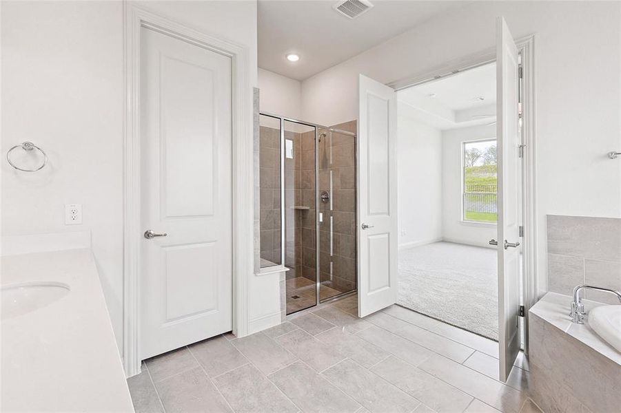 Bathroom with shower with separate bathtub, tile flooring, and sink