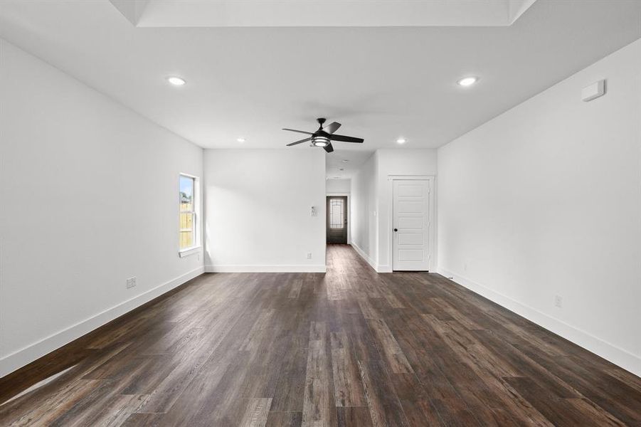 Unfurnished living room with dark hardwood / wood-style flooring and ceiling fan