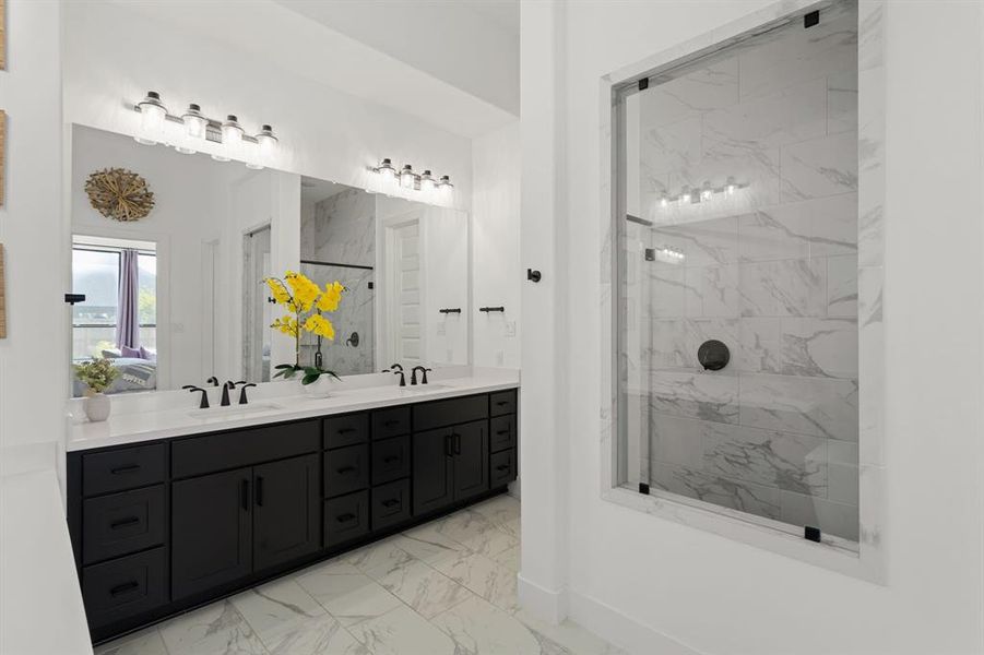 There is plenty of countertop space, double sinks, and a sizeable walk-in shower in this primary bathroom. Around the corner is a huge walk-in closet.