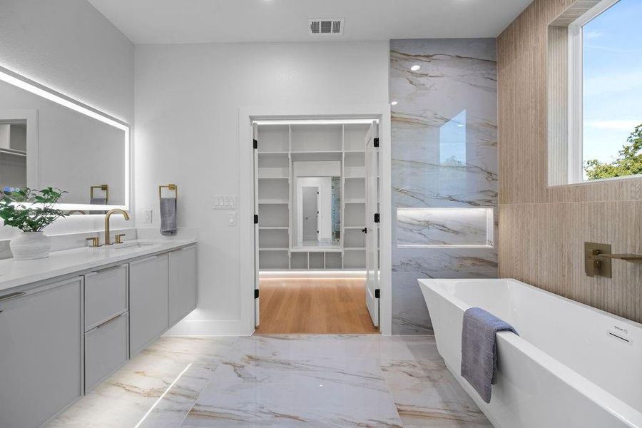 Bathroom featuring vanity, a bathtub, and tile walls