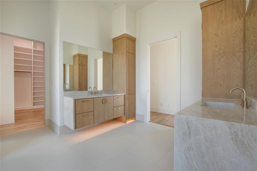 Primary Bathroom featuring a towering ceiling, hardwood / wood-style flooring, and vanity