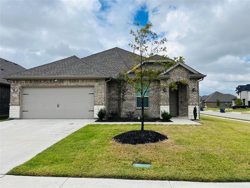 View of front of property featuring a garage and a front lawn