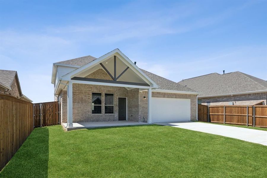 View of front of property with a garage, a front yard, and a patio