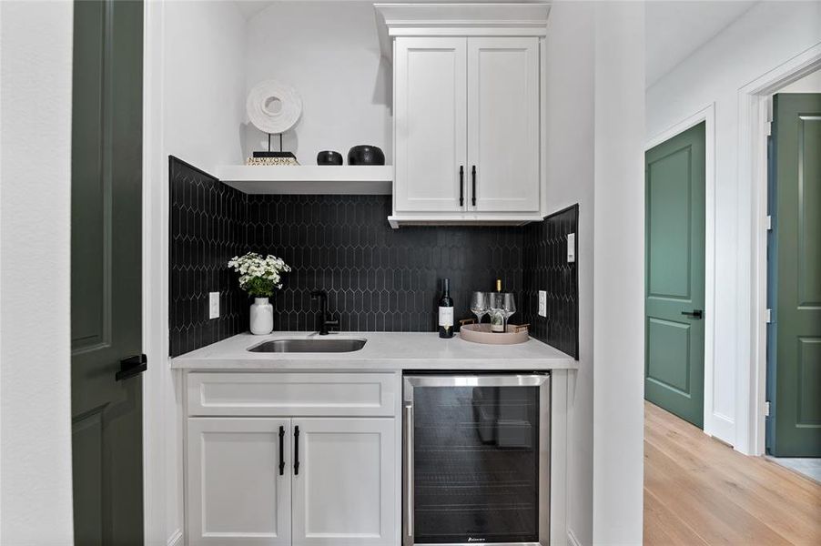 Sleek wet bar with integrated wine cooler and generous adjacent storage space.