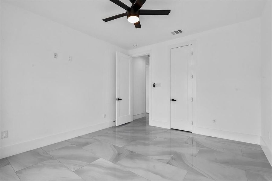 Bedroom with light tile patterned flooring and ceiling fan