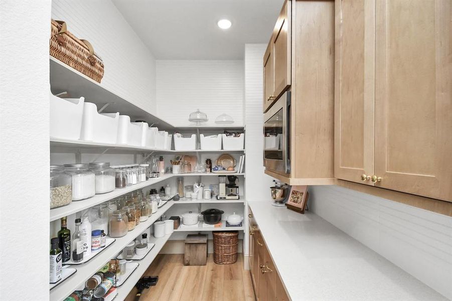 Another view of the butler's pantry showcasing the cabinetry, counter space and built-in microwave.