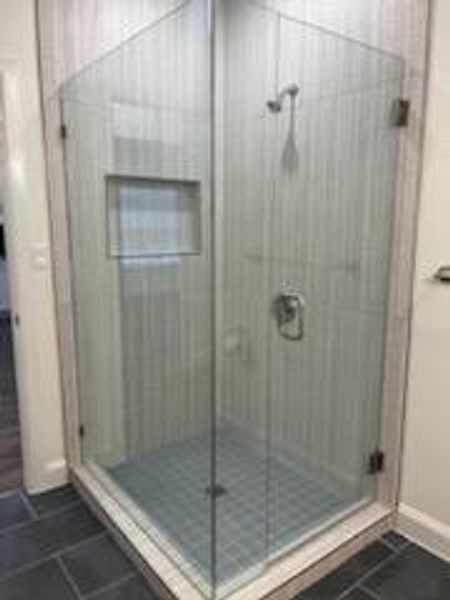 Bathroom featuring a shower with shower door and tile patterned flooring