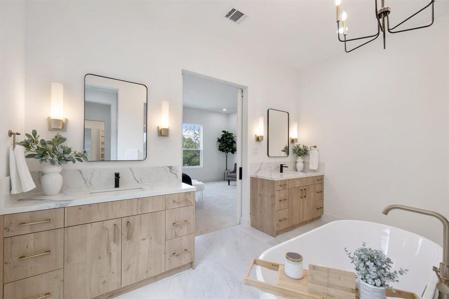 His and hers vanities accented with steel framed mirrors and brass sconces.