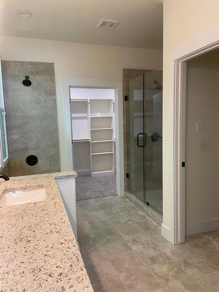 Bathroom with tile flooring, sink, and an enclosed shower