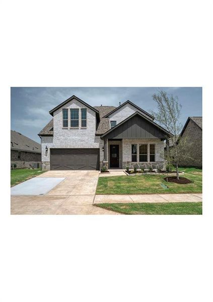 View of front facade with a front yard and a garage