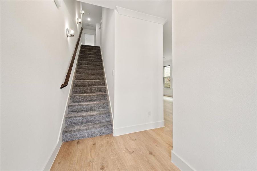 Stairway with light hardwood / wood-style floors