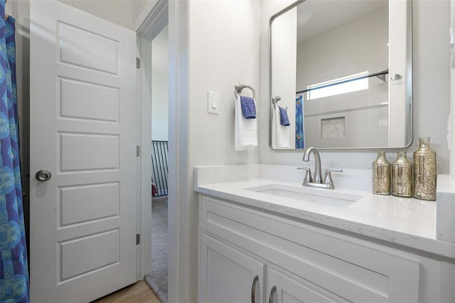 Bathroom featuring vanity with granite counters and luxury vinyl floors