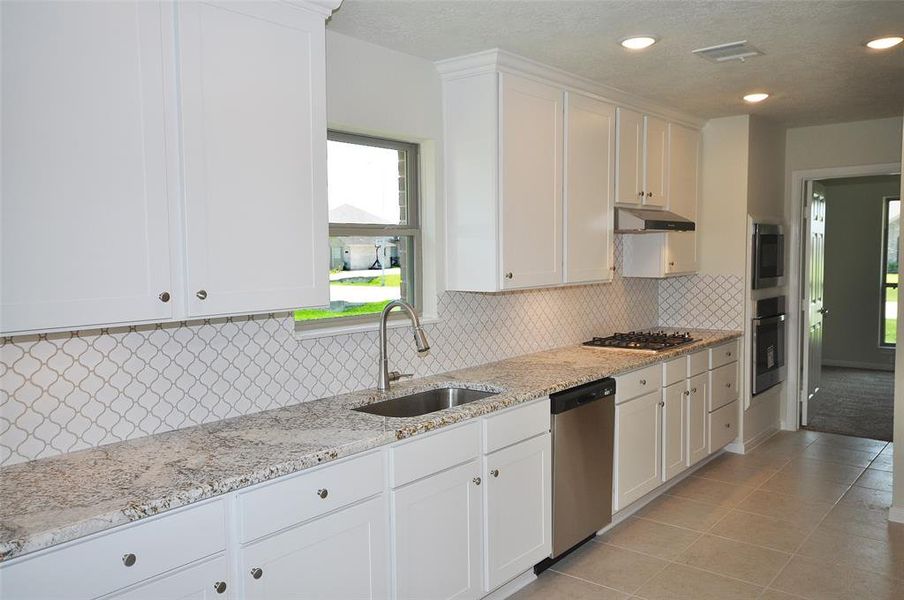 A touch of tradition - a bright and cheerful window over the undercounted stainless sink.