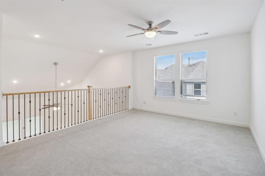 Carpeted empty room with vaulted ceiling and ceiling fan