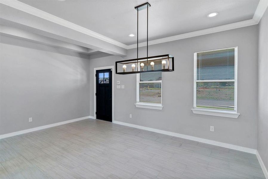 Empty room featuring an inviting chandelier and ornamental molding