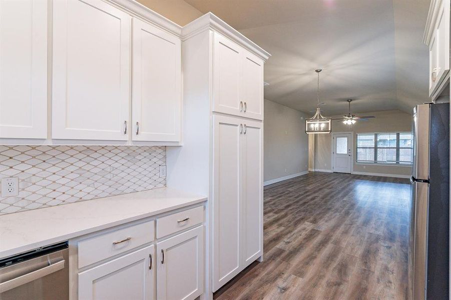 Kitchen featuring white cabinetry, stainless steel appliances, dark hardwood / wood-style floors, and tasteful backsplash