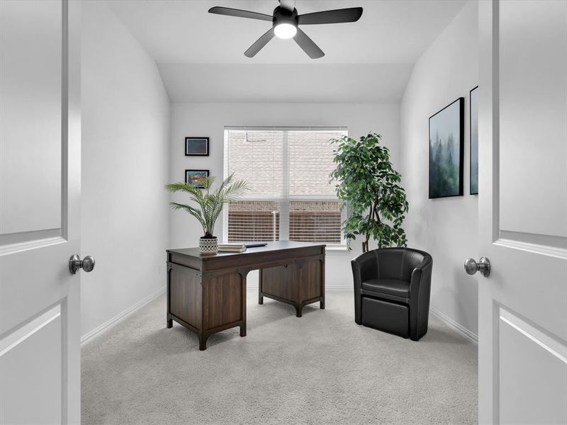 Carpeted office space featuring vaulted ceiling and ceiling fan