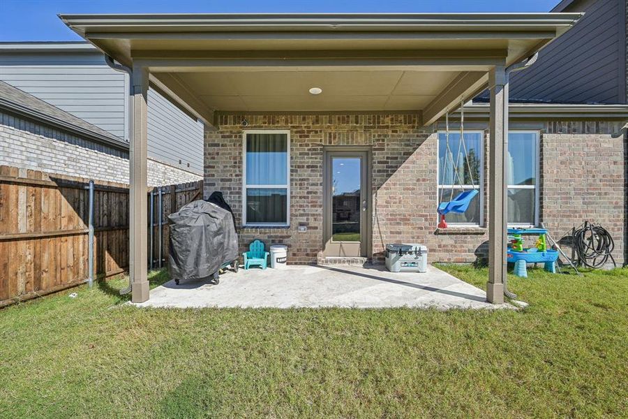 Rear view of house featuring a lawn and a patio