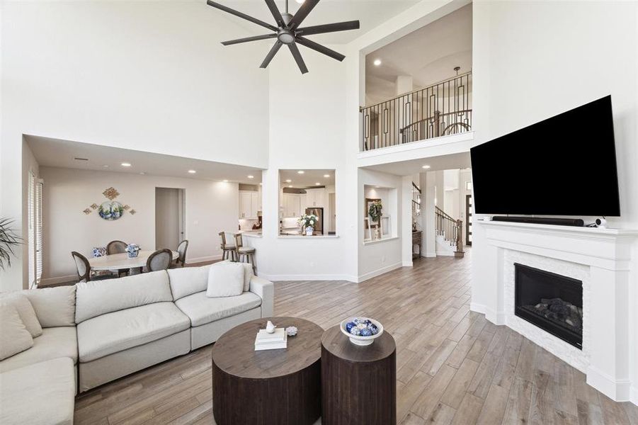 This view is from the rear of the family room toward the front entry, kitchen and breakfast area. The family room can be viewed from the upper level walkway that has wrought iron and wood railings. The walkway also overlooks the front entry from the other side.