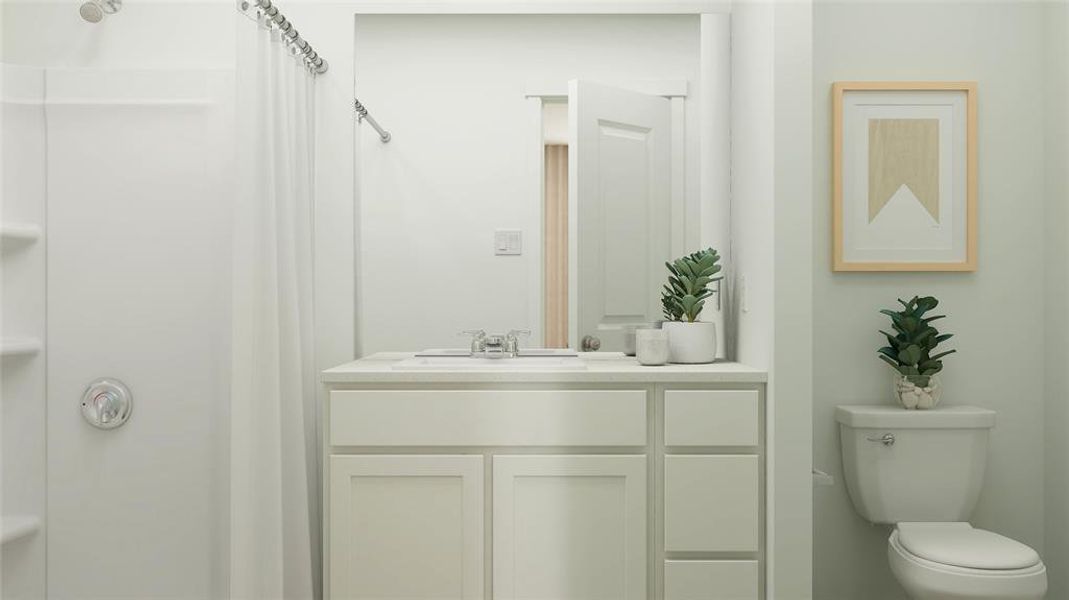 Bathroom featuring a shower with curtain, vanity, and toilet