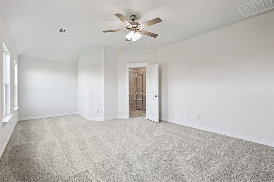 Carpeted empty room featuring ceiling fan