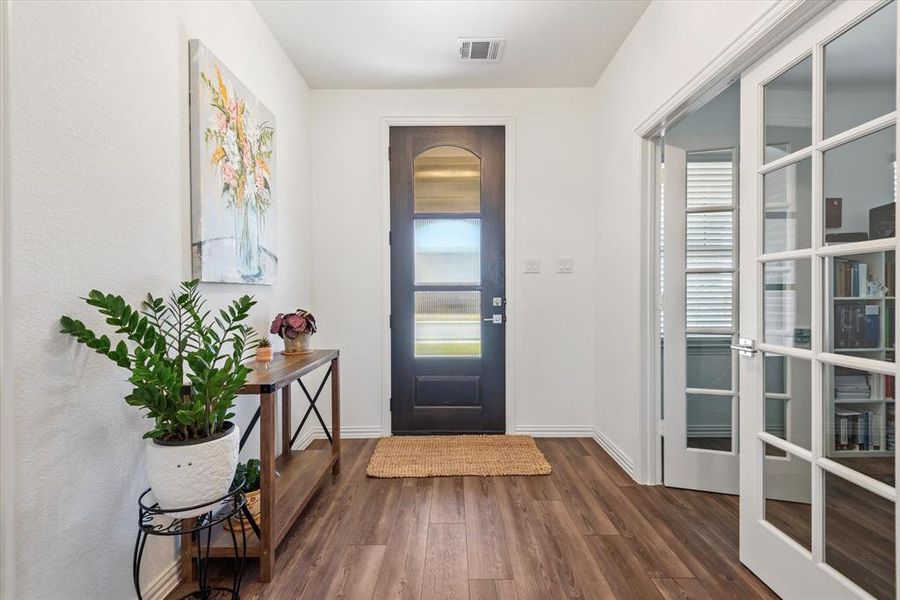 Entrance foyer with a healthy amount of sunlight and dark hardwood / wood-style flooring