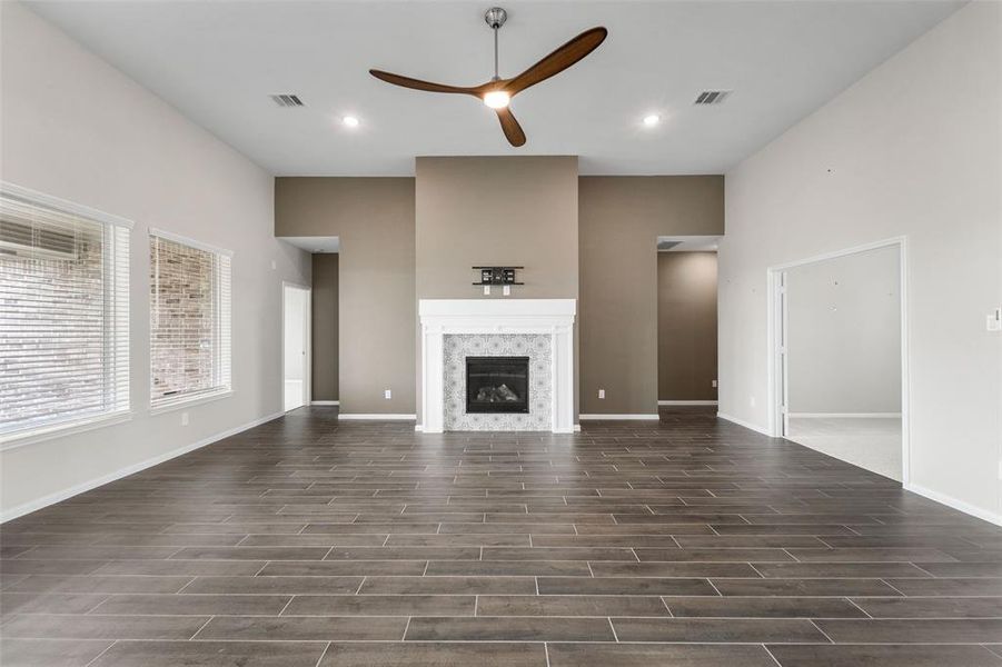 The living space is quite peaceful with high ceilings, gas log fireplace with upgraded tile detail, upgraded ceiling fan, plenty of recessed lighting, and painted accent wall