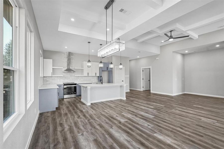 Kitchen with a kitchen island, dark hardwood / wood-style flooring, pendant lighting, stainless steel range oven, and wall chimney exhaust hood