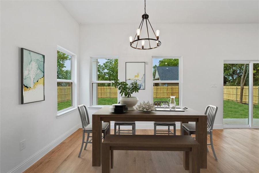 Dining area featuring light hardwood / wood-style flooring, an inviting chandelier, and a wealth of natural light