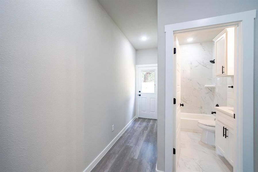 Full bathroom with toilet, wood-type flooring, vanity, and tiled shower / bath
